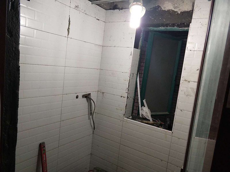 廁所裝修貼瓷磚案例：首先應(yīng)全部清理墻面上的各類(lèi)污物，打掃干凈現(xiàn)場(chǎng)，特別是腳落里；然后用泥刀先批墻，后用水泥漿找平。這個(gè)工序很重要，確保底子平，防止貼后空鼓；以及墻面要刷防水涂料，防止貼后浸水，一般高度不低于1.8米，刷的時(shí)候會(huì)稍高一些；接著把粘結(jié)劑漿料均勻的刮到墻上，記得瓷磚上墻將經(jīng)過(guò)預(yù)先清潔的瓷磚平整地鋪貼在粘結(jié)劑漿料基層上，使用橡膠錘將瓷磚拍實(shí)鋪平。施工過(guò)程中，可小幅度轉(zhuǎn)動(dòng)瓷磚，使?jié){料與瓷磚背面充分接觸。