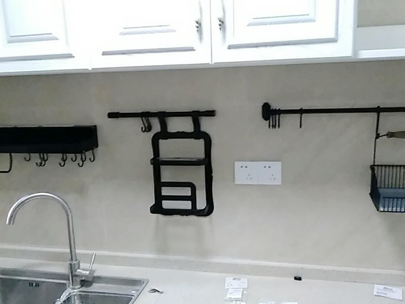 廚房五金掛件安裝：五金件的安裝一般是在瓷磚鋪貼完成后，在瓷磚上鉆孔，然后將木楔嵌入孔中，然后在上面用螺絲或膨脹螺絲將五金掛件進(jìn)行固定。
掛件在使用過(guò)程中通常會(huì)承受一定重量，加上用力按壓、拽拉或安裝不牢固等，過(guò)段時(shí)間后，多少會(huì)出現(xiàn)松動(dòng)、脫落的現(xiàn)象。在選購(gòu)此類(lèi)產(chǎn)品時(shí)，最好選擇帶有擋條的產(chǎn)品，確保上面的物品不會(huì)滑落傷人。另外，在使用前可查看其說(shuō)明，注意其最大承受重量的限度，不要超重而引起安全隱患。