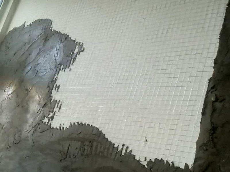 白灰墻面掛網抹灰裝修：1  基層處理：抹灰前檢查加氣混凝土墻體，對松動、灰漿不飽滿的拼縫及粱、板下的頂頭縫，用摻用水量10%的建筑膠灰漿填塞密實。將露出墻面的舌頭灰刮凈，墻面的凸出部位剔鑿平整。墻面坑凹不平處、砌塊缺楞掉角的以及剔鑿的設備管線槽、洞，應用膠灰整修密實、平順。2  灑水濕潤：將墻面浮土清掃干凈，分數遍澆水濕潤。由于加氣混凝土塊吸水速度先快后慢，吸水量慢而延續(xù)時間長，故應增加澆水的次數，使抹灰層有良好的凝結硬化條件，不致在砂漿的硬化過程中水分被加氣混凝土吸走。3  貼灰餅、沖筋：用托線板檢測一遍墻面不同部位的垂直、平整情況，以墻面的實際高度決定灰餅和沖筋的數量。