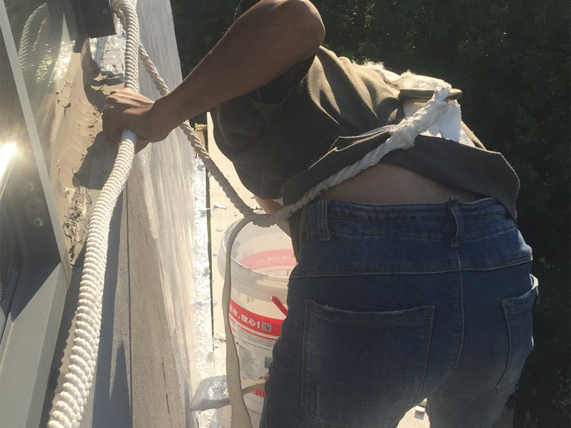 高空外墻粉刷裝修:1、基層處理：在對(duì)外墻粉刷之前，首先需要將墻面基層的灰塵與雜志清理干凈，那些比較破舊的層面與耐水性較差的涂層需要鏟除，如果表面有凹凸不平的地方，則需要用水泥砂漿進(jìn)行抹平。2、刷底膠：在對(duì)墻面刷底膠時(shí)，需要先將膠水按照說明書上注明的比例進(jìn)行稀釋，稀釋好之后，再將膠水用輥筒均勻涂刷墻面兩遍左右，注意膠水的薄厚要均勻，不能過多也不能過少。3、局部補(bǔ)膩?zhàn)樱夯鶎拥啄z干燥之后，則需用膩?zhàn)訉γ嬲移健?、滿刮膩?zhàn)樱耗佔(zhàn)臃旁谕邪逯?，讓后再用橡皮刮板?duì)墻面進(jìn)行涂刷，最好從上往下涂，最好涂刷2到三遍，需要注意的是，膩?zhàn)硬荒芡克⑻?，膩?zhàn)油克⒑笮枰蒙凹堖M(jìn)行打磨，打磨力度需要合適，打磨完之后需要將表面灰塵給清除。5、刷底涂料：采用滾筒對(duì)墻面涂刷，涂刷時(shí)需要均勻，不能漏刷，也不能刷得過厚，底料干后，如果表面有要進(jìn)行修補(bǔ)的地方，最好用膩?zhàn)舆M(jìn)行修復(fù)在進(jìn)行砂平。