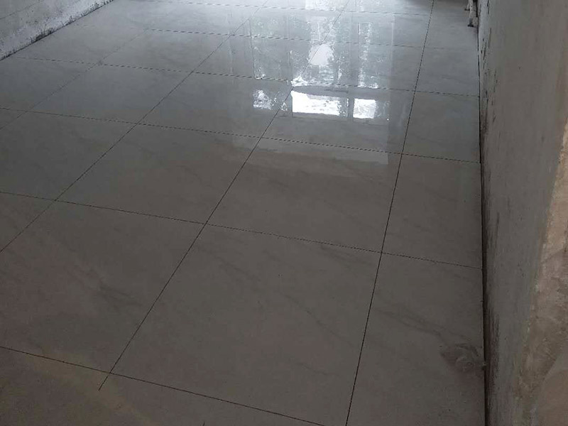 客廳地磚鋪貼裝修：首先將沙子和水泥按照3：1的比例混合后兌少量的水，使水泥和沙子混合到可以用手攥成團(tuán)的黏稠度；接著在鋪磚之前先將要鋪的地方用水潑濕。將開始和好的水泥和沙子鏟到你要鋪瓷磚的地方，鏟完以后用小鏟子初步抹平。然后瓷磚背后抹上開始和好的那盆比較稠的水泥漿，再將抹好水泥的磚小心平放到要鋪的地方，注意對縫。再用橡膠小榔頭敲實(shí)，用水平尺找平。最后在側(cè)邊用小榔頭的把手堵嚴(yán)實(shí)，完工。