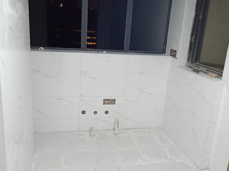 衛(wèi)生間瓷磚鋪貼：基層處理：把沾在基層上的浮漿、落地灰等用暫子或鋼絲刷清理掉，再用掃帚將浮土清掃干凈。找標(biāo)高：根據(jù)水平標(biāo)準(zhǔn)線和設(shè)計厚度，在四周墻、柱上彈出面層的上平標(biāo)高控制線。排磚：將房間依照磚的尺寸留縫大小，排出磚的放置位置，并在基層地面彈出十字控制線和分格線。鋪設(shè)結(jié)合層砂漿：鋪設(shè)前應(yīng)將基底濕潤，并在基底上刷一道素水泥漿或界面結(jié)合劑，隨刷隨鋪設(shè)攪拌均勻的干硬性水泥砂漿。鋪磚時應(yīng)先在房間中間按照十字線鋪設(shè)十字控制磚，之后按照十字控制磚向四周鋪設(shè)，并隨時用2m靠尺和水平尺檢查平整度。大面積鋪貼時應(yīng)分段、分部位鋪貼。養(yǎng)護(hù)：當(dāng)磚面層鋪貼完24h內(nèi)應(yīng)開始澆水養(yǎng)護(hù)，養(yǎng)護(hù)時間不得小于7d。