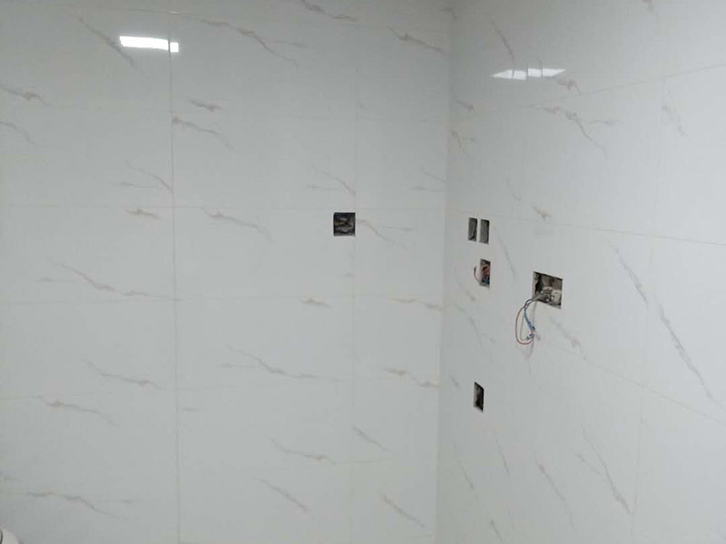 衛(wèi)生間瓷磚鋪貼：基層處理：把沾在基層上的浮漿、落地灰等用暫子或鋼絲刷清理掉，再用掃帚將浮土清掃干凈。找標(biāo)高：根據(jù)水平標(biāo)準(zhǔn)線和設(shè)計厚度，在四周墻、柱上彈出面層的上平標(biāo)高控制線。排磚：將房間依照磚的尺寸留縫大小，排出磚的放置位置，并在基層地面彈出十字控制線和分格線。鋪設(shè)結(jié)合層砂漿：鋪設(shè)前應(yīng)將基底濕潤，并在基底上刷一道素水泥漿或界面結(jié)合劑，隨刷隨鋪設(shè)攪拌均勻的干硬性水泥砂漿。鋪磚時應(yīng)先在房間中間按照十字線鋪設(shè)十字控制磚，之后按照十字控制磚向四周鋪設(shè)，并隨時用2m靠尺和水平尺檢查平整度。大面積鋪貼時應(yīng)分段、分部位鋪貼。養(yǎng)護(hù)：當(dāng)磚面層鋪貼完24h內(nèi)應(yīng)開始澆水養(yǎng)護(hù)，養(yǎng)護(hù)時間不得小于7d。