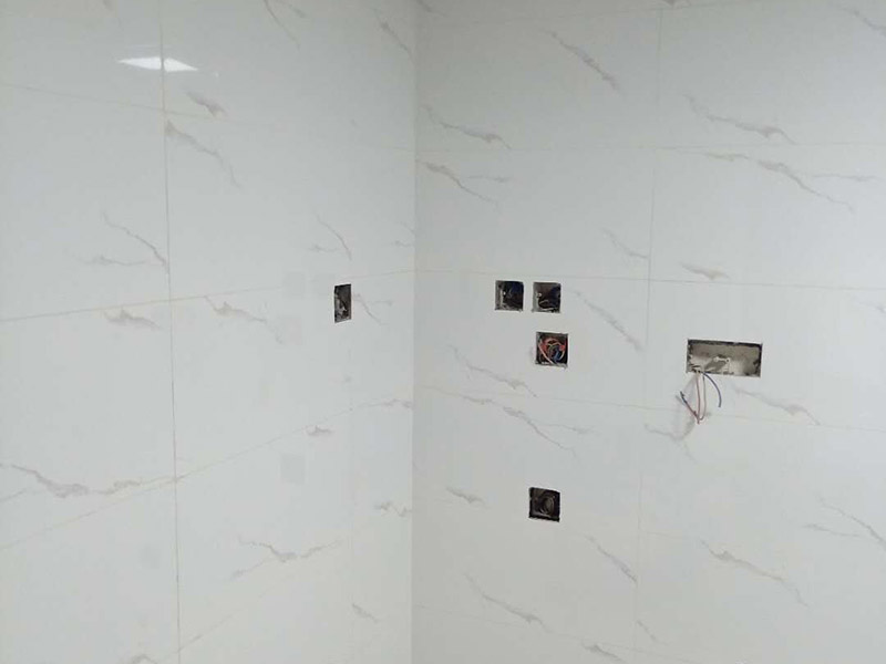 衛(wèi)生間瓷磚鋪貼：基層處理：把沾在基層上的浮漿、落地灰等用暫子或鋼絲刷清理掉，再用掃帚將浮土清掃干凈。找標(biāo)高：根據(jù)水平標(biāo)準(zhǔn)線和設(shè)計厚度，在四周墻、柱上彈出面層的上平標(biāo)高控制線。排磚：將房間依照磚的尺寸留縫大小，排出磚的放置位置，并在基層地面彈出十字控制線和分格線。鋪設(shè)結(jié)合層砂漿：鋪設(shè)前應(yīng)將基底濕潤，并在基底上刷一道素水泥漿或界面結(jié)合劑，隨刷隨鋪設(shè)攪拌均勻的干硬性水泥砂漿。鋪磚時應(yīng)先在房間中間按照十字線鋪設(shè)十字控制磚，之后按照十字控制磚向四周鋪設(shè)，并隨時用2m靠尺和水平尺檢查平整度。大面積鋪貼時應(yīng)分段、分部位鋪貼。養(yǎng)護(hù)：當(dāng)磚面層鋪貼完24h內(nèi)應(yīng)開始澆水養(yǎng)護(hù)，養(yǎng)護(hù)時間不得小于7d。