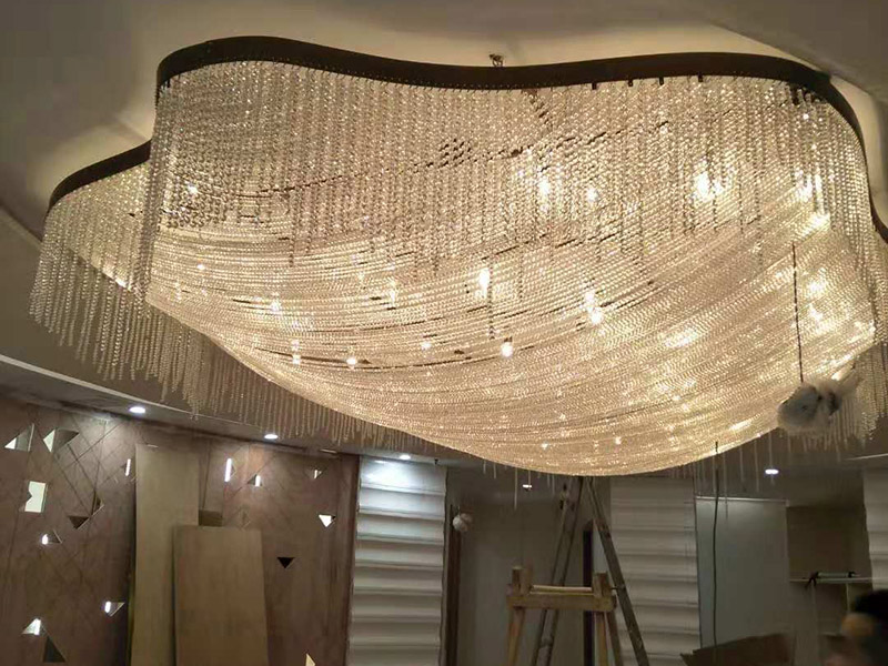 大型吊燈安裝：首先大致尺寸要測量好，確定位置；然后石膏板上鉆孔，然后埋設(shè)鐵件五金配件或者木條，用黏貼劑或者水泥漿將空洞的周邊補齊，等到差不多干燥了再接下來做。接著把鐵件或者木條固定，這是吊燈安裝的重要步驟，如果沒有固定好，使用壽命會受到影響。電線通過吊桿引入到燈芯里面，如果配套燈帶使用開關(guān)的，穿線的時候要注意線路的走向。最后就是燈罩、燈臂的安裝。用看、螺絲刀等工具將燈罩組裝好，安裝好后，通電試試就可以了，根據(jù)實際情況稍微調(diào)整下。