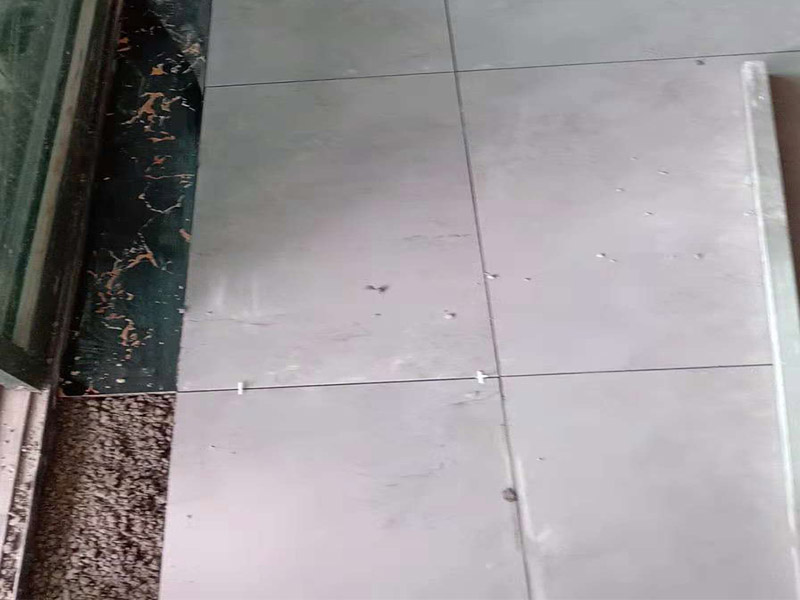 客廳地磚鋪貼：鋪貼的工具包括橡膠錘和粘結(jié)劑。在進(jìn)行施工之前先把所需要的這些材料都整理好放在一旁備用；基層的處理工作對(duì)瓷磚的平整度有很大的影響，對(duì)于基層要做好清潔工作，還有找平工作。放樣：在進(jìn)行瓷磚的鋪貼工作之前還事先找好垂直線，這樣可以在鋪貼的時(shí)候找到瓷磚的水平線，讓瓷磚鋪貼的更加的平整。粘結(jié)劑加水?dāng)嚢杈鶆颍o置10分鐘之后就可以使用。將瓷磚表面的浮灰清除，再在瓷磚背面均勻的涂抹上粘結(jié)劑，按照預(yù)鋪的順序?qū)⒋纱u鋪貼在地面上，最后用橡膠錘輕輕拍打至服帖齊整。