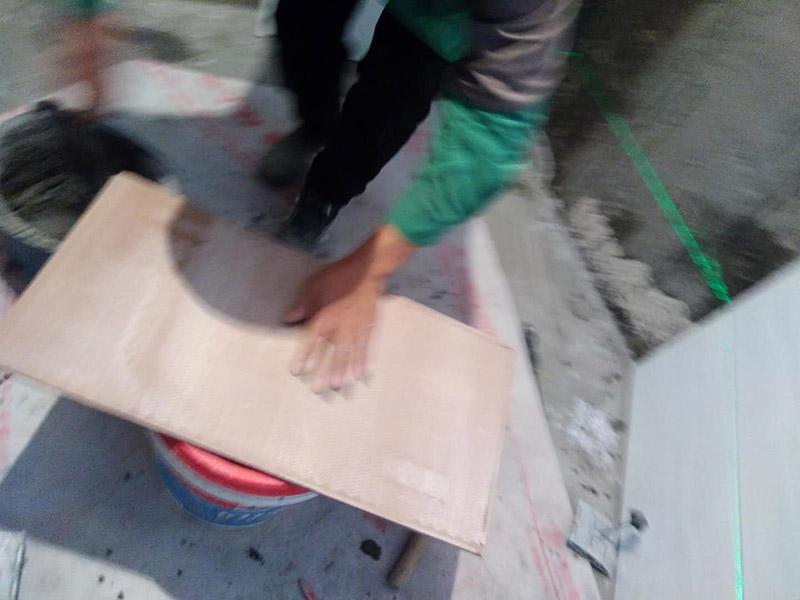 廁所墻面貼瓷磚：廁所貼瓷磚：首先應(yīng)除去基層表面的污垢，油漬，浮灰;除去基層上所有涂料層，膩子層;如果基層未能達到平整度要求，需對基層進行預(yù)先的找平處理；鋪貼瓷磚前需事先找好垂直線，以此為基準(zhǔn)鋪貼的瓷磚高低均勻、垂直美觀；應(yīng)對瓷磚的色彩、紋理、表面平整等進行嚴(yán)格的挑選，然后按照圖紙要求預(yù)鋪，調(diào)制粘結(jié)劑；然后將調(diào)制好的漿料均勻地抹在瓷磚背面，要求漿料飽滿，瓷磚平整地鋪貼在基層上，使用橡膠錘將瓷磚拍實鋪平；最后瓷磚鋪貼結(jié)束后24小時，可進行嵌縫施工，嵌縫后用浸濕的織物清理多余的嵌縫劑，保持瓷磚表面清潔。