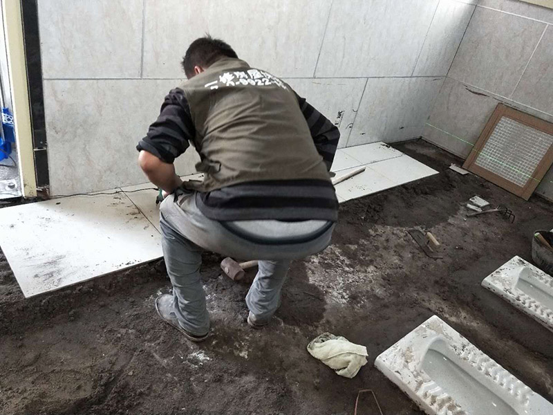 公廁貼磚維修：基層處理：應(yīng)全部清理墻面上的各類污物，打掃干凈現(xiàn)場，特別是腳落里。 批墻、墻面找平：用泥刀先批墻，后用水泥漿找平。這個工序很重要，確保底子平，防止貼后空鼓。 刷防水涂料：墻面要刷防水涂料，防止貼后浸水，一般高度不低于1.8米，刷的時候會稍高一些。 找水平基準(zhǔn)線：根據(jù)設(shè)計鋪貼圖樣的要求，確定排磚方案，用墨斗彈線，以減少施工損耗。 粘結(jié)劑上墻：把剛剛攪拌好的粘結(jié)劑漿料均勻的刮到墻上。 瓷磚上墻將經(jīng)過預(yù)先清潔的瓷磚平整地鋪貼在粘結(jié)劑漿料基層上，使用橡膠錘將瓷磚拍實鋪平。施工過程中，可小幅度轉(zhuǎn)動瓷磚，使?jié){料與瓷磚背面充分接觸。專家建議在鋪貼時，隨機取下已鋪貼于基層上的瓷磚作檢查。確保漿料與瓷磚背面的充分接觸。 留縫大小調(diào)整根據(jù)瓷磚的尺寸，在磚與磚之間預(yù)留相應(yīng)尺寸的縫隙留待嵌縫?？捎醚篮灥认裙潭?，粘結(jié)劑具有一定的可調(diào)整性，可對留縫的大小進(jìn)行調(diào)整。