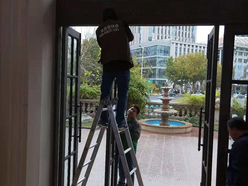 室外門維修：首先安裝門框，這個門檻是事先量好尺寸制作好的。把門框靠在門洞里，一般是安裝門扇的那邊靠墻。并使用沖擊鉆鉆孔，安裝2只膨脹螺絲。然后打安裝孔，使用膨脹螺絲穿過門框，在門框的后面適當(dāng)?shù)募尤?個斜頭木楔，并使用卷尺量好同樣的寬度，通過調(diào)節(jié)斜頭木楔的長短達(dá)到合適的寬度。緊固好2只膨脹螺絲后就可以把門扇放入門框里，查看尺寸是否合適。并安裝門框上的合頁。把合頁對好位置，并使用鉚釘槍打入鉚釘，固定合頁，然后再在合頁上打第二個孔和安裝鉚釘。同樣的步驟安裝好門框下的合頁。完成2只合頁的安裝后就把門扇放入門框里，以合頁的安裝位置為基礎(chǔ)，移動門扇，達(dá)到最佳安裝位置。如果門扇短一些，就可以在門扇底部墊斜頭進(jìn)行支墊。位置合適后使用記號筆做好合頁螺絲安裝孔位置。再使用手槍鉆鉆孔和使用鉚釘槍加入鉚釘。打開門查看移動是否靈活，再完成剩下的孔的鉚釘安裝。