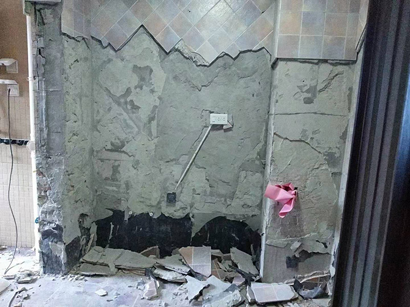 廚房拆除施工：墻面上應(yīng)該還有些其他東西，比如掛毛巾的架子，放廚具的架子等等。先把這些物品都小心翼翼的拆下來，還原一面光潔的墻面，才好進(jìn)行拆卸工作。先用垂子敲最下面的那塊磚，把瓷磚敲松動(dòng)。送動(dòng)后，再用戴了手套的手把瓷磚拿下來，小心碎了瓷磚不要?jiǎng)澋绞至恕γ鎯?nèi)有些地方會(huì)走一些管道，有煤氣管道，有電線管道，水管，網(wǎng)線等等。要注意這些管道，不要把墻里面的管道破壞了，不然拆了瓷磚又惹了新的問題要處理。拆卸下來的瓷磚堆積在地上很不方便繼續(xù)工作，這個(gè)時(shí)候上面提到的推車就派上用場了。用推車把瓷磚運(yùn)走，清理干凈現(xiàn)場，然后繼續(xù)拆卸，直到整面的墻面都拆卸完整。