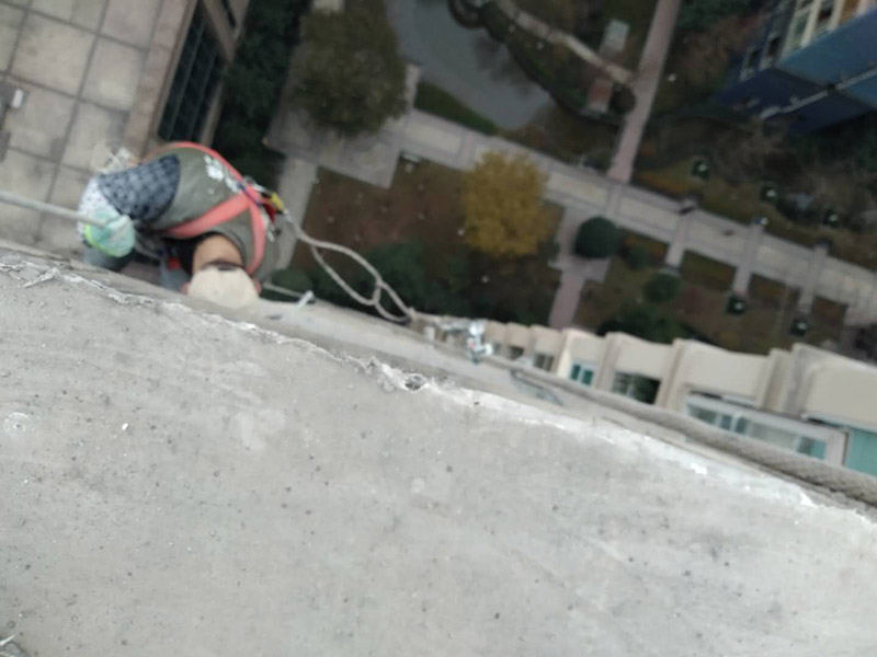 高空外墻防水：清理基層，新舊面層必須清理干凈，不得有雜物和灰塵，以免影響粘結(jié)強(qiáng)度，涂刷防水涂料時(shí)基層應(yīng)干燥。接下來，清理死角，也就是所謂的陰陽角、施工縫、伸縮縫等比較重要的部位進(jìn)行處理，尤其注意的是泄水孔要加強(qiáng)處理，需要涂刷2-3遍防水底層涂料。將攪拌均勻的防水涂料根據(jù)現(xiàn)場(chǎng)要涂刷的面積開始涂刷，基層涂刷要大于粘卷材的面積，不要超過三十分鐘，涂刷第二次涂料之前必須要等第一次涂料完全凝固后方可再次涂刷，底層涂料第一次涂刷完畢后約4-8小時(shí)左右，方可再次涂刷第二次和第三次底層涂料，第一次涂刷厚度為0.5mm、第二次涂刷厚度為0.5mm左右、第三次涂刷厚度為0.5mm左右。粘結(jié)卷材時(shí)要等第二次涂料完全凝固后方可施工。