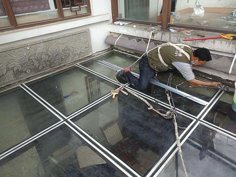 陽光房打防水膠：在陽光房施工完成后，如果陽光房與墻體有銜接的地方，一定要記住鏟去墻體上原有的涂料，否則粘合陽光房與墻體的膠水就不能很好的發(fā)揮粘合的作用，等到膠水完全凝固后會損壞墻體的涂料，造成陽光房的滲漏。最好的解決方法就是事先鏟去原墻體上涂料，在打膠之后，在陽光房與墻體接縫處上覆蓋防水擋板并且安裝一個排水槽，這樣就可以確保陽光房不漏水。