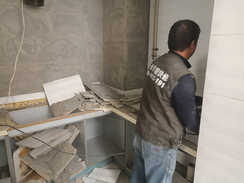 廚房瓷磚拆除：墻面上應(yīng)該還有些其他東西，比如掛毛巾的架子，放廚具的架子等等。先把這些物品都小心翼翼的拆下來，還原一面光潔的墻面，才好進(jìn)行拆卸工作。拆卸的時候要先從墻低的第一塊磚開始拆卸，要是直接隨便從上面那一塊拆卸，拆到一半就會擋住下面的瓷磚，讓下面的瓷磚不好拆了。先用垂子敲最下面的那塊磚，把瓷磚敲松動。送動后，再用戴了手套的手把瓷磚拿下來，小心碎了瓷磚不要劃到手了。拆卸下來的瓷磚堆積在地上很不方便繼續(xù)工作，這個時候上面提到的推車就派上用場了。用推車把瓷磚運走，清理干凈現(xiàn)場，然后繼續(xù)拆卸，直到整面的墻面都拆卸完整。