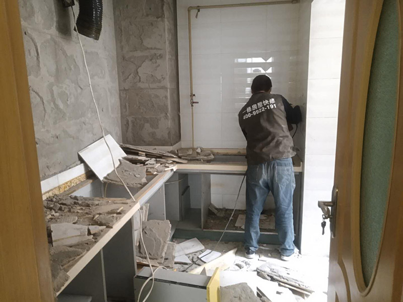 廚房瓷磚拆除：墻面上應(yīng)該還有些其他東西，比如掛毛巾的架子，放廚具的架子等等。先把這些物品都小心翼翼的拆下來，還原一面光潔的墻面，才好進(jìn)行拆卸工作。拆卸的時候要先從墻低的第一塊磚開始拆卸，要是直接隨便從上面那一塊拆卸，拆到一半就會擋住下面的瓷磚，讓下面的瓷磚不好拆了。先用垂子敲最下面的那塊磚，把瓷磚敲松動。送動后，再用戴了手套的手把瓷磚拿下來，小心碎了瓷磚不要劃到手了。拆卸下來的瓷磚堆積在地上很不方便繼續(xù)工作，這個時候上面提到的推車就派上用場了。用推車把瓷磚運走，清理干凈現(xiàn)場，然后繼續(xù)拆卸，直到整面的墻面都拆卸完整。