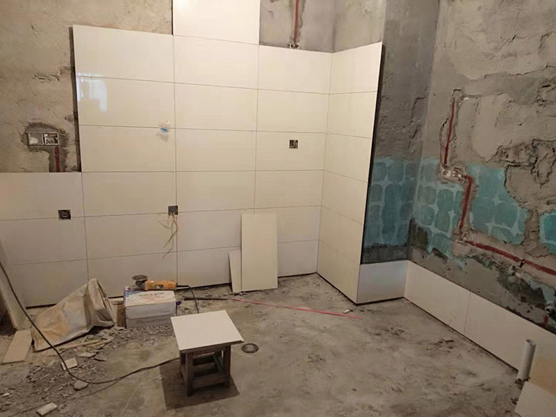 浴室墻面貼瓷磚：貼瓷磚之前先要用水浸泡瓷磚2小時左右。泡水的目的是為了讓瓷磚能事先吸飽水分，避免鋪貼之后吸走粘接材料中的水分，從而影響粘接的強(qiáng)度，浸水后記得用棉布擦去表面的水分晾干后才能進(jìn)行鋪貼。鋪貼開始前還應(yīng)吊垂線，來確定瓷磚的尺寸線，然后開始貼瓷磚，一般都是從門窗先開始，而且按由下而上，自左至右的順序進(jìn)行。鋪貼的方法是先用水潤濕找平層，然后用鏟子將事先拌好的粘接材料抹在瓷磚背面，再將瓷磚貼在墻上即可，依次鋪貼平整就可以了。