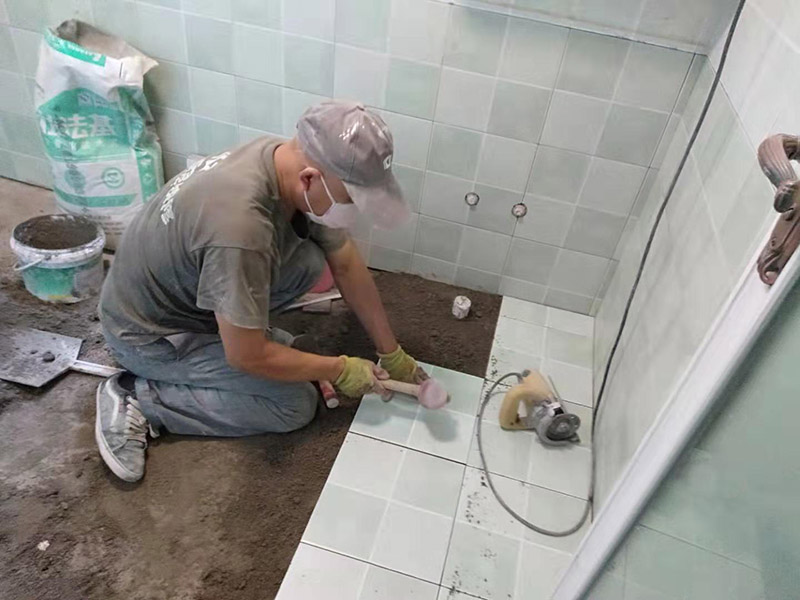 廁所地面貼瓷磚：首先將選購(gòu)好的瓷磚清潔干凈，并du在水中浸泡2個(gè)小時(shí)以上，瓷磚的浸泡是為了能讓瓷磚充分的吸收水分，避免在鋪貼完成之后吸取材料中的水分，而影響瓷磚與地面的粘貼度，造成起空鼓、脫落等現(xiàn)象，開(kāi)始鋪貼瓷磚之前需要從水中取出并將便面的水分擦去，以便鋪貼。 設(shè)置輔助線在開(kāi)始瓷磚進(jìn)行鋪貼之前，需先在墻面上吊垂線，吊垂線是用來(lái)確定瓷磚與墻面的尺寸，再設(shè)置水平線，這樣能夠保證瓷磚鋪貼過(guò)程中保持橫平豎直的平整度。 順序鋪貼通常地磚的鋪貼都是由門(mén)窗邊或者陽(yáng)臺(tái)開(kāi)始的，保證從上到下，由左及右的順序行進(jìn)，先用水潤(rùn)曾找平層，再用鏟子將水泥抹在瓷磚的背面，再將瓷磚貼在地面，再用橡膠錘輕輕敲擊瓷磚，使水泥充滿墻面與瓷磚之間的空隙。