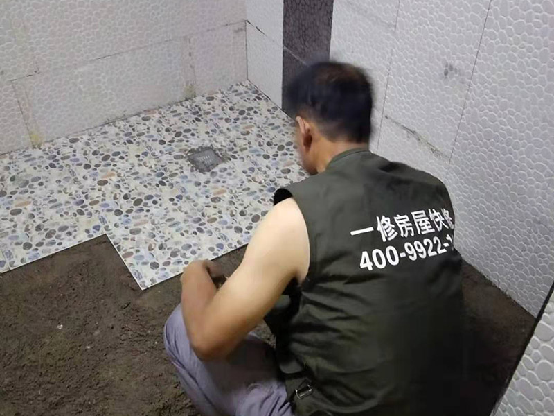 衛(wèi)生間地面花磚鋪貼:找平，就是在鋪仿古磚前，對鋪貼物表面進行處理，如地面、內(nèi)墻面、外墻面等，消除表面附著的污物，并灑水進行滋潤，然后用水泥沙混合找平，通常使用灰鏟在表面不停的涂抹使水泥地面保持大致水平，一定要等到水泥沙混合物完全干爽后再行鋪貼。用一段較長的細線，根據(jù)確定的鋪貼方式，在線上涂上顏色或白灰，然后在找平的地面上畫出仿古磚的位置及磚縫的參考線。 將亞光磚置入清水中浸泡，使瓷磚充分吸收水分，以不冒出氣泡為準，防止干燥瓷磚在裝修完成后再次吸水而導致磚體變形。取出浸泡好的瓷磚，抹干水漬，在找平層上噴灑足夠的水，然后在磚背面均勻抹上水泥沙漿，沙漿厚度5~6cm為宜，鋪貼大規(guī)格亞光磚時適當加厚；隨即將磚貼上，用木錘輕輕拍牢平整，避免空鼓，并隨時用直尺找平。