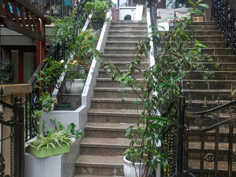 戶外樓梯加花壇：用測(cè)量?jī)x器把花壇群中主花壇中心點(diǎn)坐標(biāo)測(cè)量到地面上，再把縱橫中軸線上的其他中心點(diǎn)的坐標(biāo)測(cè)設(shè)下來，將各中心點(diǎn)連線，即在地面上放出花壇群的縱橫軸線。放線完成后，應(yīng)沿著已有的花壇邊線開挖邊緣石基槽?；鄣拈_挖寬度應(yīng)比邊緣石基礎(chǔ)寬10厘米左右，深度可在12～20厘米之間。槽底土面要整平、夯實(shí)，有松軟處要進(jìn)行加固，不得留下不均勻沉降的隱患。在砌基礎(chǔ)之前，槽底還應(yīng)做一個(gè)3～5厘米厚的粗砂墊層，用于基礎(chǔ)施工找平。