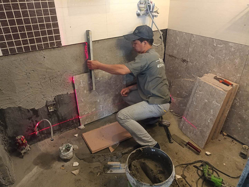 衛(wèi)生間貼磚施工：施工工藝流程; 基層處理--抹底子灰--彈線排磚--侵磚--鑲貼--擦縫--交工驗(yàn)收 用一比三的水泥砂漿打底,打底厚度5~~7mm，待底子灰干六七成干時(shí)候，按圖紙要求，進(jìn)行彈線，排磚。立好皮數(shù)桿，排磚形式有主要兩種直縫和錯(cuò)縫。當(dāng)?shù)孛嬗蟹核臅r(shí)候，注意安排好泛水。侵泡瓷磚，時(shí)間不少于兩個(gè)小時(shí)，陰干通常是3~~5小時(shí)。瓷磚在鑲貼時(shí)候，瓷磚下口坐在八字尺或直尺上。鋪貼的方式有離縫和無(wú)縫。鑲貼瓷磚從陽(yáng)角開(kāi)始，自下向上貼，瓷磚背面刀灰，貼上用力壓，用鏟刀木柄輕輕敲打，鋪貼時(shí)候砂漿飽滿，缺灰重貼，不得塞灰，貼6~~8塊，用靠尺校正。水管處先鋪周圍整塊磚，后鋪異型磚。最后擦縫。