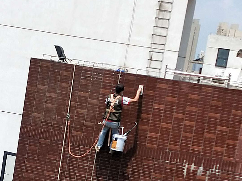 高空外墻防水：外墻面洞和較大裂縫防水密封前用噴水槍等工具將待治理的外墻面、伸縮縫、窗框等部位清理干凈，使施工的外墻面及縫、孔、洞部位達(dá)到無油、無塵土、無水泥松散顆粒等雜物。   待其干燥后，將孔、洞、縫用防水密封材料嵌填密實(shí)，并達(dá)到與原顏色一致，再用快速堵漏靈和透明防水膠膜進(jìn)行精心施工。整體條形瓷磚外墻面防水，采用高效環(huán)保型憎水進(jìn)行精心施工。該材料具有防水性能優(yōu)異、透氣性能良好、施工方便、使用安全、質(zhì)量可靠、耐久性好等特點(diǎn)。