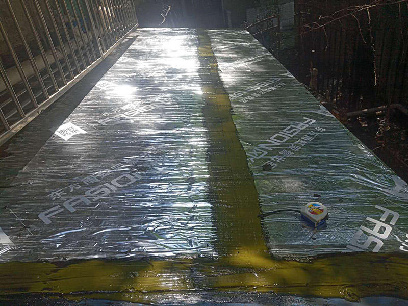 雨棚防水施工：1、待軟性防水層充分冷卻后，將塑料彩條棚布鋪設其上形成浮筑層(兩塊棚布須重疊)，起剛性水泥層和軟性防水層滑動間隔用。 2、鋪設5厘米厚的細石混凝土，內用4毫米直徑的鐵絲結成孔徑小于10&times;10厘米的鐵絲網，加強混凝土的抗拉力。 3、剛性水泥層與女兒墻、立墻間留分格縫，可有效地防止其開裂。 4、大面積屋頂須設置分格縫，縫隙2厘米，鋼筋在分格縫必須分開?；炷脸浞指赏负?，分格縫內清掃干凈，并填充防水油膏。分格縫因順坡度設置并錯開軟性防水層接縫。因分格縫的防水質量難保證，必須嚴格操作。 5、剛性層鋪設時，表面必須形成坡度，加快積水排出屋面。 整個防水屋面鋪設完畢后，防水層由七層組成：防水油膏、油毛氈、防水油膏、油毛氈、防水油膏、塑料彩條棚布、混凝土。