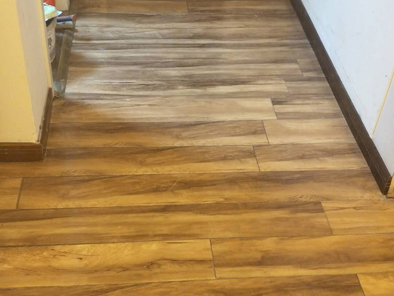 入戶門鋪地板：1、先對地面進(jìn)行找平，水平的誤差不能超過2毫米。地面要是不平，腳感就不好。再就是將邊、角部位等突起或有不平的地方進(jìn)行局部修整。再鋪防潮層，防潮層可以防止以后地板受潮。鋪平，接縫處要并攏。  2、然后就是安裝地板了，因為地板是要錯落安裝的，先預(yù)鋪一下，將部分地板一分為二，要按尺寸來鋸，萬一鋸多了，地板損耗就大了。因為地板有一定的膨脹率，因此鋪裝前要在其與墻面接觸的部位預(yù)留膨脹縫，以免地板起鼓。膨脹縫的大小一般和地板的膨脹系數(shù)有關(guān)系。粘合地板的膠水要用強(qiáng)化地板專用的，這種膠的污染比較小。不要隨便在市場上選非地板專用膠，地板本身就存在的污染上再增加污染源。  3、鋪前看好地板是否用對，再鋪設(shè)地板。在鋪設(shè)時，要一塊短的旁邊鋪一塊長的，這樣交叉鋪設(shè)地板就咬得住不易松動，地板拼合后還要用工具敲緊。再下來就是銜接了，一般用地板壓條掩蓋。但也有用玻璃膠填充。