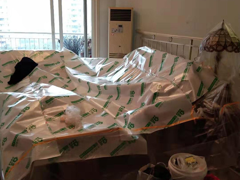 全屋家具成品保護：滿鋪成品瓦楞紙板，再用干凈彩條布滿鋪在普通石膏板上，在彩條布交接處及轉(zhuǎn)角處用膠帶固定，也可選用木芯板或三夾板。材料選用視上人、車情況而定。 所有成品飾面板在安裝好后必須用PE保護膜覆蓋包起來，所有成品飾面板的陽角位必須用硬質(zhì)紙護角或泡沫棉進行保護性包裝，防止交被其他施工人員碰撞。 1、入戶門扇用公司統(tǒng)一的門貼進行全面包裹保護，用透明膠帶將保護膜粘貼牢固平整。 2、用標準保護膜將門框三面保護完整并固定牢固。 3、工程完工后拆除保護膜時如果有粘貼時的膠痕，應用酒精或?qū)Ｓ玫那逦蹌┣宄z痕。