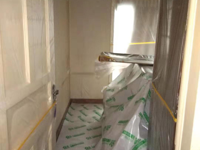 全屋家具成品保護：滿鋪成品瓦楞紙板，再用干凈彩條布滿鋪在普通石膏板上，在彩條布交接處及轉(zhuǎn)角處用膠帶固定，也可選用木芯板或三夾板。材料選用視上人、車情況而定。 所有成品飾面板在安裝好后必須用PE保護膜覆蓋包起來，所有成品飾面板的陽角位必須用硬質(zhì)紙護角或泡沫棉進行保護性包裝，防止交被其他施工人員碰撞。 1、入戶門扇用公司統(tǒng)一的門貼進行全面包裹保護，用透明膠帶將保護膜粘貼牢固平整。 2、用標準保護膜將門框三面保護完整并固定牢固。 3、工程完工后拆除保護膜時如果有粘貼時的膠痕，應用酒精或?qū)Ｓ玫那逦蹌┣宄z痕。