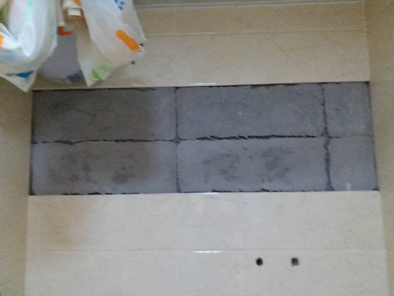 墻面瓷磚脫落修補：首先將脫落的磚四周用裁紙刀的刀背咔嚓一遍，將勾縫劑或水泥等附著物清理掉，漏出瓷磚的原邊。同時需要清理的，還有墻上與脫落瓷磚相連的瓷磚邊緣。當然，用刀刃也可以，但比較毀刀片。然后用稍微潮濕的抹布擦干凈瓷磚背面的浮灰，最好用鋼絲球來刷一遍瓷磚背面再擦，目的是去掉可能存在的脫模劑。接著就是清理墻面的水泥砂漿層，將松動的碎塊去掉，然后也整體用抹布擦一遍。將玻璃膠用裁紙刀切掉密封出口，如果有槍嘴就擰上槍嘴，沒有也可以直接用。如果墻上的水泥砂漿四周有縫隙，可在縫隙內(nèi)也擠些玻璃膠，這樣可以連接那些沒掉的瓷磚，防止附近的瓷磚將來也脫落。然后將這背面抹膠的瓷磚貼回原處，磚與磚之間插上牙簽來留縫隙。再用手指抹玻璃膠到磚與磚之間的縫隙里。