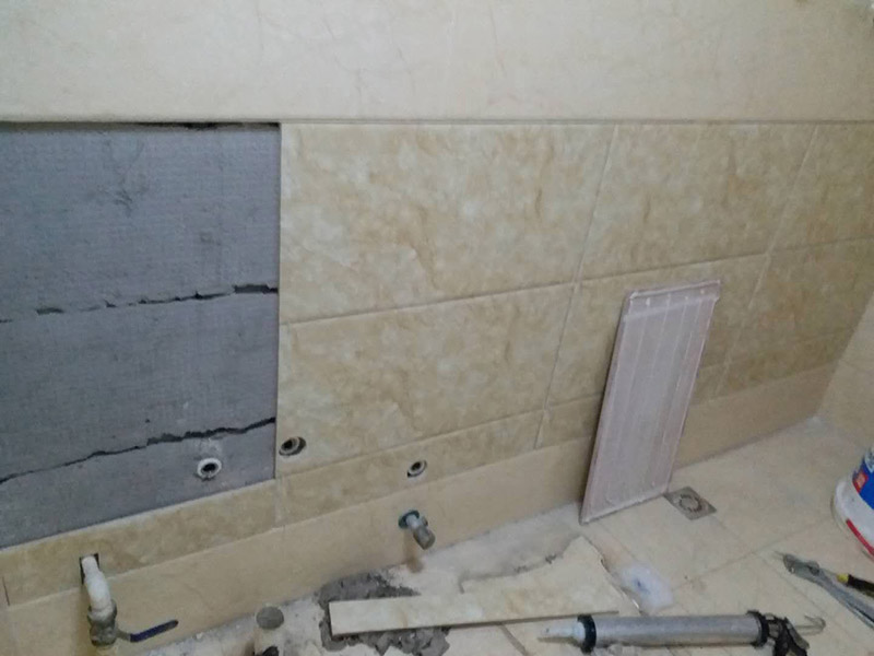 墻面瓷磚脫落修補：首先將脫落的磚四周用裁紙刀的刀背咔嚓一遍，將勾縫劑或水泥等附著物清理掉，漏出瓷磚的原邊。同時需要清理的，還有墻上與脫落瓷磚相連的瓷磚邊緣。當然，用刀刃也可以，但比較毀刀片。然后用稍微潮濕的抹布擦干凈瓷磚背面的浮灰，最好用鋼絲球來刷一遍瓷磚背面再擦，目的是去掉可能存在的脫模劑。接著就是清理墻面的水泥砂漿層，將松動的碎塊去掉，然后也整體用抹布擦一遍。將玻璃膠用裁紙刀切掉密封出口，如果有槍嘴就擰上槍嘴，沒有也可以直接用。如果墻上的水泥砂漿四周有縫隙，可在縫隙內(nèi)也擠些玻璃膠，這樣可以連接那些沒掉的瓷磚，防止附近的瓷磚將來也脫落。然后將這背面抹膠的瓷磚貼回原處，磚與磚之間插上牙簽來留縫隙。再用手指抹玻璃膠到磚與磚之間的縫隙里。