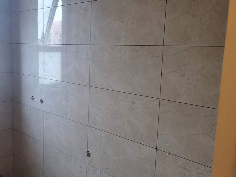 地磚墻磚鋪貼方案：在鋪貼墻磚之前，需要對其進(jìn)行基層處理。先將基層表面的灰塵和污漬清理干凈，然后在將其表面的膩?zhàn)訉雍屯苛蠈尤コ蓛?。同時(shí)，還應(yīng)對基層的平整度進(jìn)行檢查，如果基層不平，則還需要用水泥砂漿找平，否則會(huì)影響墻磚的鋪貼效果。基層清理干凈后，還不能直接鋪設(shè)墻磚，而是要先在墻體四周用墨線彈出幾條標(biāo)高控制線，并在地面彈出十字線，控制好每塊地磚的尺寸。調(diào)制好粘結(jié)劑之后，就可以開始準(zhǔn)備鋪貼墻磚了。在鋪貼前，要對墻磚產(chǎn)品表面的灰塵和污垢進(jìn)行清理。處理干凈后，便可將事先配置好的漿料涂抹在瓷磚背面，注意在涂抹漿料的時(shí)候要涂的均勻和飽滿。將涂抹了漿料的墻磚按照之前預(yù)鋪的花紋樣式進(jìn)行鋪貼，鋪貼平整之后，再用橡膠錘子將其拍平鋪實(shí)，增強(qiáng)其穩(wěn)定性。同時(shí)，在這個(gè)過程中，還可稍微的轉(zhuǎn)動(dòng)一下墻磚，讓瓷磚背面與漿料充分接觸，緊密融合。