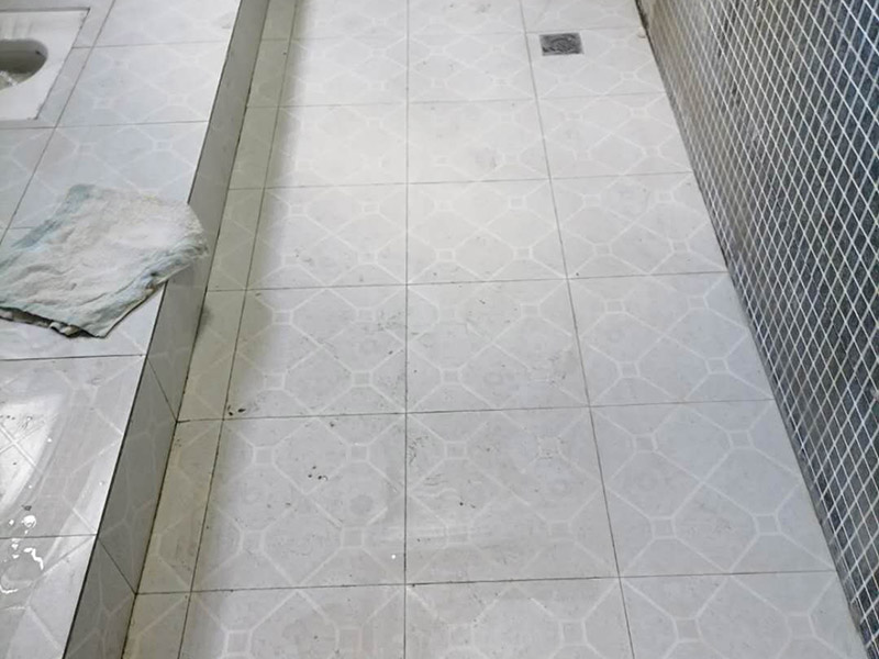 公共衛(wèi)生間貼磚施工：清理墻面上的各類污物，打掃干凈現(xiàn)場，特別是腳落里。用泥刀先批墻，后用水泥漿找平。這個工序很重要，確保底子平，防止貼后空鼓。墻面要刷防水涂料，防止貼后浸水，一般高度不低于1.8米，刷的時候會稍高一些。瓷磚上墻將經(jīng)過預(yù)先清潔的瓷磚平整地鋪貼在粘結(jié)劑漿料基層上，使用橡膠錘將瓷磚拍實鋪平。施工過程中，可小幅度轉(zhuǎn)動瓷磚，使?jié){料與瓷磚背面充分接觸。留縫大小調(diào)整根據(jù)瓷磚的尺寸，在磚與磚之間預(yù)留相應(yīng)尺寸的縫隙留待嵌縫。可用牙簽等先固定，粘結(jié)劑具有一定的可調(diào)整性，可對留縫的大小進行調(diào)整。