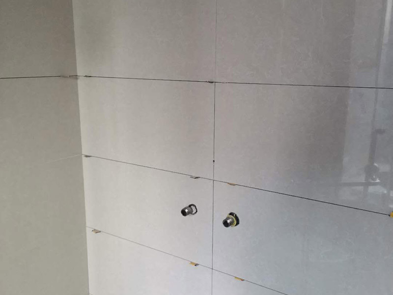 瓷磚空鼓維修鋪貼：首先，先使用空鼓錘敲擊墻面確認空鼓范圍。如果敲擊的聲音比較沉悶的話，說明鋪貼比較實也比較牢固。反之，發(fā)出&ldquo;咚咚&rdquo;清脆的聲響的話，說明瓷磚存在空鼓。然后在開孔處注射瓷磚空鼓修復(fù)膠。如有溢出的膠水盡量在干固之前用濕抹布擦掉，如填縫處有膠水滲出是因為原有的填縫劑密度不夠，可重新涂抹一層密度較大的填縫劑。最后使用填縫劑填補孔位，擦掉多余的填縫劑。