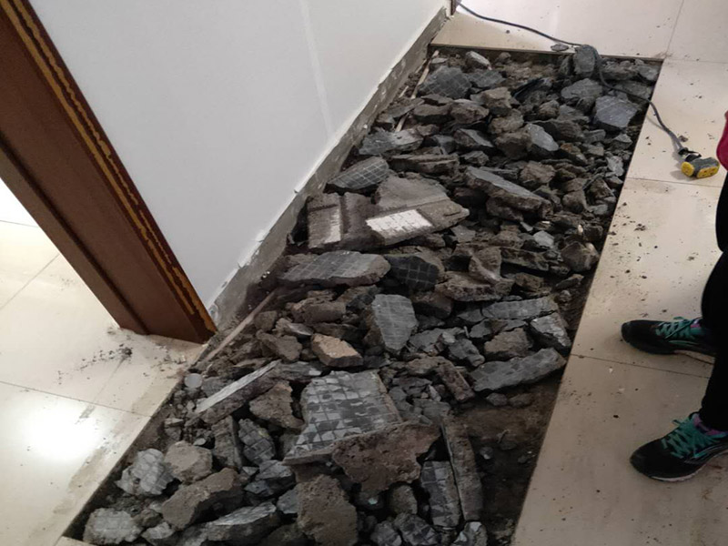 全屋瓷磚拆除施工:首先要撬開大門口的那塊地磚，因?yàn)槟菈K地du磚是有一邊露在外面的所以比較容易撬開。再用扁的鑿子一片一片的往里撬，如果水泥砂漿做的不是特別牢固的話可以直接用錘子把扁撬敲擊地磚和水泥地中間的縫隙。