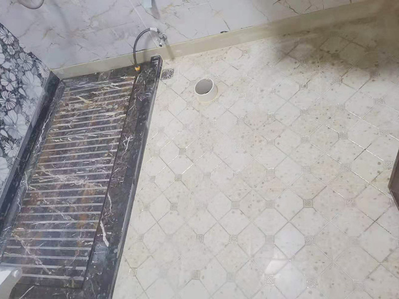 衛(wèi)生間地面防水裝修:首先要將墻面地面都要清潔干凈，這點非常重要，不能有散沙、土、石塊等干擾基層。如果基層開發(fā)商做的很不好的話，表面還要刷一層界面劑以防止墻面表面起沙。用噴壺將陰角部分和管根部分噴水，噴水的主要目的就是防止墻面吸收了堵漏寶太多的水分，造成堵漏寶沒有和墻面凝結(jié)在一起。那么噴多少水呢，建議以表面沒有明顯積水為宜。刷完以后，由于速凝型的堵漏寶干燥較快，所以基本不用等待，干的非?？臁Ｈ缓髮⒌谝槐槎侣毶箱伜镁W(wǎng)格布，主要是防止堵漏寶初凝以后裂開。然后進行第二遍涂刷堵漏寶，刷完咱們就要進行下面柔韌性防水涂刷的步驟了。