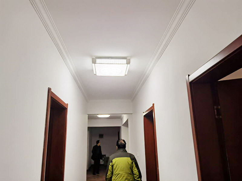 墻面粉刷滾乳膠漆：先將裝修表面上的灰塊、浮渣等雜物用開刀鏟除，如表面有油污，應(yīng)用清洗劑和清水洗凈，干燥后再用棕刷將表面灰塵清掃干凈;表面清掃后，再用底層石膏或嵌縫石膏將底層不平處填補(bǔ)好，石膏干透后局部需貼牛皮紙或?qū)Ｓ脡Σ歼M(jìn)行防裂處理，干透后進(jìn)行下一步施工。 遍應(yīng)用膠皮刮板滿刮，要求橫向刮抹平整、均勻、光滑，密實(shí)平整，線角及邊棱整齊為度。盡量刮薄，不得漏刮，接頭不得留槎，注意不要沾污門窗框及其他部位，否則應(yīng)及時清理。待遍膩?zhàn)痈赏负?，用粗砂紙打磨平整。注意操作要平衡，保護(hù)棱角，磨后用棕掃帚清掃干凈。 第二遍滿刮膩?zhàn)臃椒ㄍ椋文ǚ较蚺c前膩?zhàn)酉啻怪?。然后用粗砂紙打磨平整，否則必須進(jìn)行第三遍、第四遍，用300W太陽燈側(cè)照墻面或天棚面用粗砂紙打磨平整，用細(xì)砂紙打磨平整光滑為準(zhǔn)。