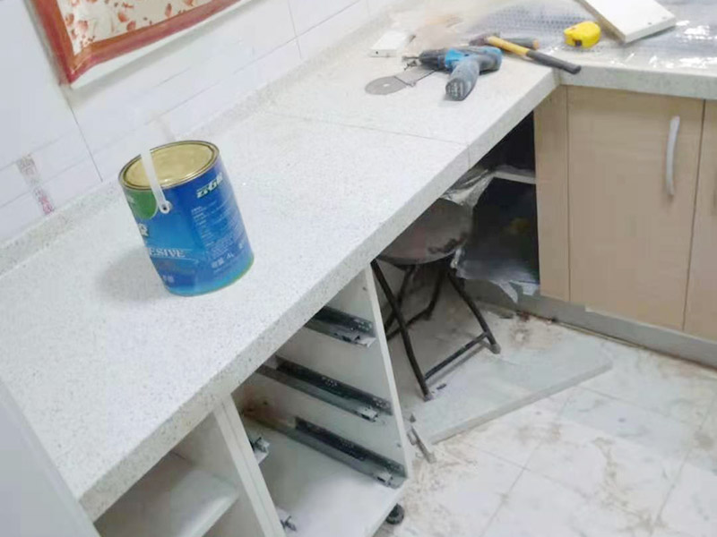 櫥柜維修改造：對廚房作防護措施,掛擋布、廚房墻面等做簡單清理,以便準確測量地面水平。 材料進場:櫥柜板材等進場。  安裝地柜 組裝:統(tǒng)一組裝好地柜,搬進廚房,按圖紙順序擺放好位置(倒放),統(tǒng)一安裝地腳。 現場切割:地面上墊上保護物,割口根據實物的大小從反面進行操作,保持正面不崩。 安裝順序：如有轉角柜應先安轉角柜，沒有轉角柜先從靠墻的柜往外安裝。 水平調整：通過地柜的調節(jié)腿調節(jié)地柜水平度，誤差保持正負1mm。