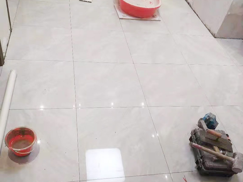 客廳地磚鋪貼:鋪貼前應(yīng)用水泥砂漿找地面或墻面，并按磚體尺寸劃好線，劃線時需預(yù)留3－5mm的灰縫，以防粘結(jié)物與磚體膨脹系數(shù)不一致而導致不良后果產(chǎn)生。 瓷磚受熱或者冬天遇冷會存在一定熱脹冷縮，同時粘貼瓷磚的水泥沙土也會隨著溫度和濕度的變化出現(xiàn)一定膨脹收縮，瓷磚間不留縫隙很容易導致瓷磚起拱裂開。瓷磚邊緣存在一定誤差，每塊瓷磚不能保證完全的平整，特別是裝修現(xiàn)場切割瓷磚容易出現(xiàn)誤差，留縫能保持整體整齊劃一。 