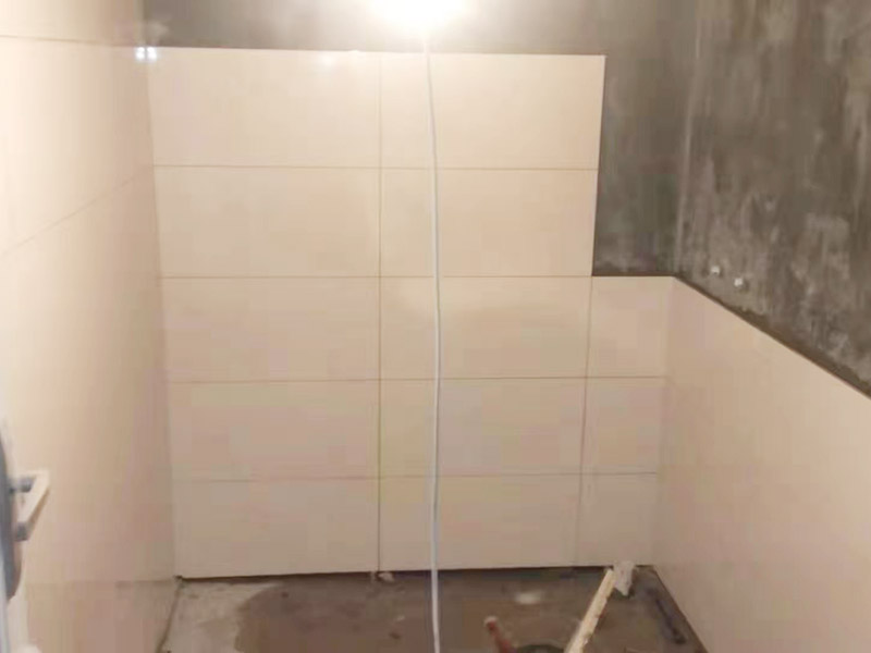 衛(wèi)生間墻面貼磚：首先應(yīng)除去基層表面的污垢，油漬，浮灰;除去基層上所有涂料層，膩?zhàn)訉?如果基層未能達(dá)到平整度要求，需對(duì)基層進(jìn)行預(yù)先的找平處理。鋪貼瓷磚前需事先找好垂直線，以此為基準(zhǔn)鋪貼的瓷磚高低均勻、垂直美觀;此外，施工前在墻體四周需彈出標(biāo)高控制線，在地面彈出十字線，以控制地磚分隔尺寸。對(duì)瓷磚的色彩、紋理、表面平整等進(jìn)行嚴(yán)格的挑選，然后按照?qǐng)D紙要求預(yù)鋪。對(duì)可能出現(xiàn)的尺寸、色彩、紋理誤差等進(jìn)行調(diào)整、交換，直至達(dá)到最佳效果。 調(diào)制粘結(jié)劑：加水后將粘結(jié)劑漿料攪拌至潤(rùn)滑均勻，無(wú)明顯塊狀或糊狀結(jié)塊，攪拌后的漿料靜置5-10分鐘后再稍加攪拌1-2分鐘即可使用。 將瓷磚平整地鋪貼在基層上，使用橡膠錘將瓷磚拍實(shí)鋪平。施工過(guò)程中，可小幅度轉(zhuǎn)動(dòng)瓷磚，使?jié){料與瓷磚背面充分接觸。