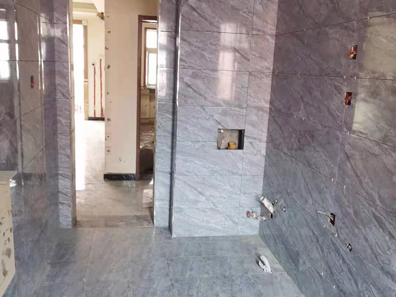 全屋瓷磚鋪貼：首先應(yīng)除去基層表面的污垢，油漬，浮灰;除去基層上所有涂料層，膩?zhàn)訉?如果基層未能達(dá)到平整度要求，需對(duì)基層進(jìn)行預(yù)先的找平處理。鋪貼瓷磚前需事先找好垂直線，以此為基準(zhǔn)鋪貼的瓷磚高低均勻、垂直美觀;此外，施工前在墻體四周需彈出標(biāo)高控制線，在地面彈出十字線，以控制地磚分隔尺寸。加水后將粘結(jié)劑漿料攪拌至潤滑均勻，無明顯塊狀或糊狀結(jié)塊，攪拌后的漿料靜置5-10分鐘后再稍加攪拌1-2分鐘即可使用。將瓷磚平整地鋪貼在基層上，使用橡膠錘將瓷磚拍實(shí)鋪平。施工過程中，可小幅度轉(zhuǎn)動(dòng)瓷磚，使?jié){料與瓷磚背面充分接觸。