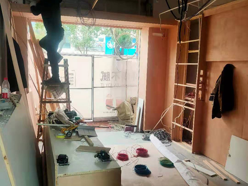 門店木工施工現(xiàn)場:首先應(yīng)該搭建木作施工臺。木作施工臺用于板材的切割板，板材的造型，板材的平整度處理等等。門窗的制作包括門窗套制作、門窗制作。要特別注意門窗扇與框之間的縫隙不能太大，以及門窗套與門窗的色差等。木作表層封裝木制品制作完成后，對其表面進行細(xì)節(jié)封裝。木作表層封裝通常就要用到各種各樣的家裝板材，特別注意板材的選購。