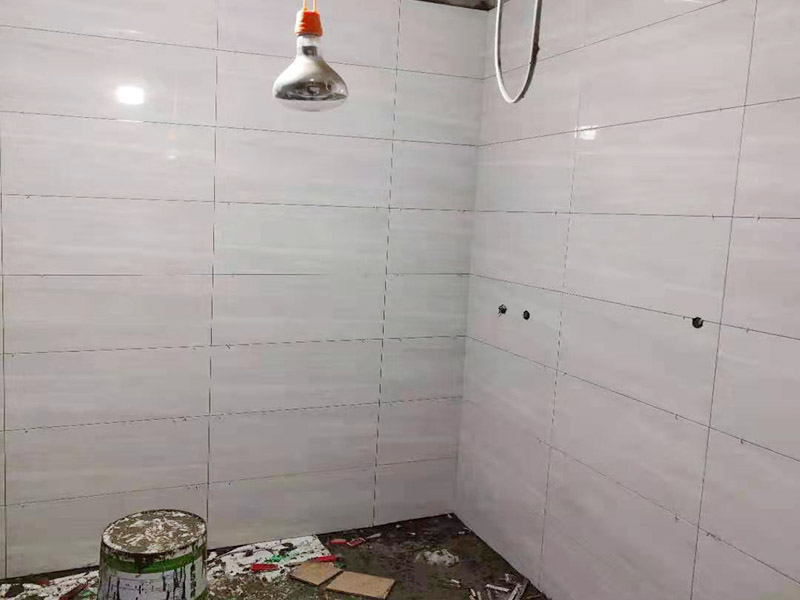 浴室貼磚裝修:把還沒有涂抹水泥的地磚鋪在地上，把它們敲平，然后在地磚上涂滿水泥，鋪在地面，保持四塊磚的對角位置對齊。 鋪瓷磚的順序其實(shí)也是有不少講究的，鋪地磚的時候應(yīng)該從內(nèi)向外貼，遇到坡度或者有地漏的地方，還要注意排水方向找坡；墻面磚的鋪貼應(yīng)該從下向上進(jìn)行。為了最后的鋪貼效果美觀，最底層的瓷磚要最后貼；墻面磚鋪貼結(jié)束以后還要壓地磚。 這里要注意的是，貼瓷磚的時候不能一面墻貼到頂，否則由于瓷磚較重容易引起脫落。鋪好了地磚盡量不要去踩。 因?yàn)榇纱u本身有許多小孔，吸水能力強(qiáng)，干燥的瓷磚會吸干水泥的水分.