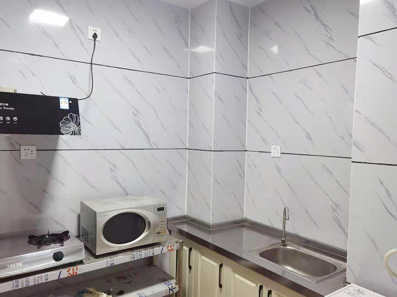 出租房廚房墻貼微晶板：將粘有圖案的轉(zhuǎn)移膜輕輕的撕離圖案的底紙，如果圖案有沒粘在轉(zhuǎn)移膜上的地方，可以用小刀輔助一下。先將轉(zhuǎn)移膜剪下的邊角料挑選個墻角的墻面測試一下墻面的性能，確定墻面沒問題后再粘貼。如果墻面掉粉或在撕下轉(zhuǎn)移膜時會連同墻面漆一起粘下，請?zhí)幚砗笤龠M行粘貼?！≠N圖案的時候，可以先將轉(zhuǎn)移膜的一角先粘在墻上，然后慢慢的將粘有圖案的轉(zhuǎn)移膜順著向下的方向貼在墻上，接著用卡片由圖案中間向四周的方向反復劃幾下，使墻貼更好粘在墻壁。