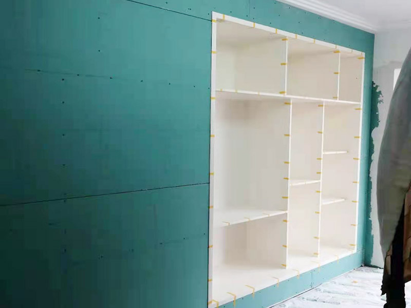 客廳定制柜體安裝：用墊布點好地板，先從靠墻的一端寬側(cè)板開始組裝，將寬側(cè)板平放于地面上（離后墻面保持700mm間隔）。首先將填好的三合一膠塞的板件，平放在墊布上，檢查孔距與圖紙相符，并裝上三合一單連桿。然后將固層釘上木塞，固定于寬側(cè)板上面，頂板大柄孔朝上，其余固層都朝下，腳線大柄孔朝內(nèi)（中間固層與L架高度一致，即底板到固層內(nèi)空為960mm，現(xiàn)場打?qū)影蹇祝?。放上?cè)板，釘上木塞，木塞要求連通兩邊的固層。在第二個柜固層上面裝好雙連桿，留意雙連桿上面大柄只能鎖住一半，即90&deg;。當(dāng)兩件固層與側(cè)板固定后再同時擰緊大柄。裝第三個柜時重復(fù)第二個柜的安裝步驟。