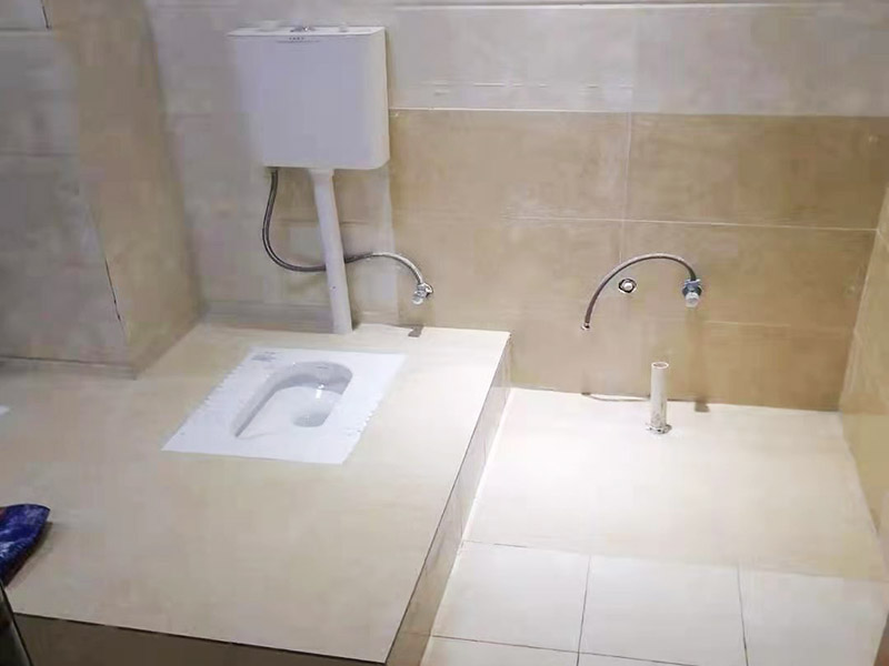 蹲便器安裝貼磚裝修：1.根據(jù)所安裝產(chǎn)品的排污口，在離墻適當(dāng)?shù)奈恢妙A(yù)留下水管道，同時確定下水管道入口距地平面的距離。 2.在地面下預(yù)留安裝蹲便器的凹坑深度大于便器的高度。 3.將連接膠塞放入蹲便器的進(jìn)水孔內(nèi)卡緊。在與蹲便器進(jìn)水孔接觸的外邊緣涂上一層玻璃膠或油灰，將進(jìn)水管插入膠塞進(jìn)水孔內(nèi)，使其與膠塞密封良好，以防漏水。 4.在蹲便器的出水口的邊緣涂上一層玻璃膠或油灰，放入下水管道的入口旋合，用焦渣或其它填充物將便器架設(shè)水平。 5.打開進(jìn)水系統(tǒng)，檢查各接合處有無漏水情況，若出現(xiàn)漏水，則要檢查各接合處的情況。直至問題解決。 6.檢查各接合處無漏水情況后，用填充物將便器周圍填實(shí)，同時陶瓷與水泥砂漿的接觸面填上 1cm 以上的瀝青或油氈等彈性材料。 7.用水泥砂漿將蹲便器固定在水平面內(nèi)，平穩(wěn)、牢固后，然后在水泥面上鋪貼衛(wèi)生間地磚。 8.試沖水，若無異常即可使用。