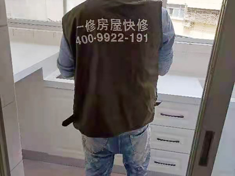 舊櫥柜更換安裝：櫥柜安裝一般先從地柜開(kāi)始。把櫥柜外包裝拆開(kāi)后。在櫥柜的邊緣貼上防火膜封邊。在下柜底部安裝上支腳，根據(jù)地面水平高度調(diào)整櫥柜。 櫥柜安裝需要找出基準(zhǔn)點(diǎn)，L型廚房從直角處向兩邊延伸，U型廚房則先將中間的一字型柜體放整齊后，再?gòu)膬蓚€(gè)直角處向兩邊站看，這樣可以避免出現(xiàn)縫隙。 櫥柜框架安裝牢固定位后，需要在櫥柜背面。一般安裝下水都會(huì)現(xiàn)場(chǎng)開(kāi)孔，工人會(huì)用專(zhuān)業(yè)的打孔器按照管道大小進(jìn)行打孔，打孔的直徑應(yīng)比管道大3-4毫米，并且打孔后要將開(kāi)孔部分用密封條封邊，防止邊緣滲水木材變形。把打好孔的背板根據(jù)櫥柜位置，依次封裝進(jìn)去。接下去就是安裝吊柜了。同下柜一樣，吊柜也需要根據(jù)需要現(xiàn)場(chǎng)打孔，比如脫排油煙機(jī)的排煙管的孔位。