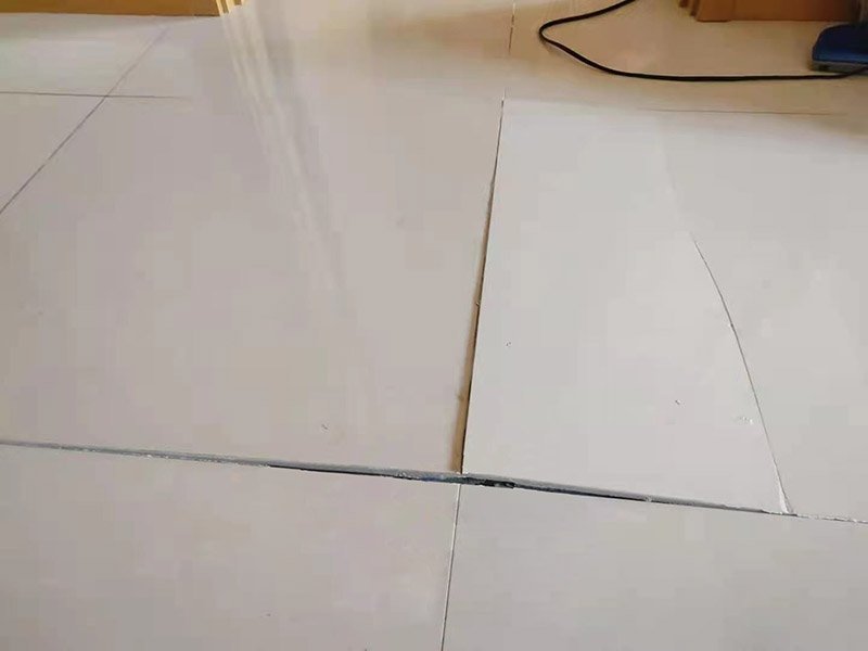 客廳地磚起翹修復(fù)：將油灰刀的邊緣滑入松散的瓷磚與其旁邊的瓷磚之間的接縫中。撬起瓷磚并將其移除。用金屬刮刀或小的撬桿的平坦邊緣刮掉基材和瓷磚背面的稀釋劑或瓷磚粘合劑。用相同的工具刮擦周圍空間的舊水泥漿。用清水沖洗除去翹起的瓷磚，然后用濕海綿擦拭，使其干凈。將砂漿抹在缺口邊緣上，然后將稀釋水泥砂漿抹在瓷磚的背面，將瓷磚鋪回原位。如果難以將瓷磚平整，則將瓷磚墊片插入接縫或修補物與包圍它的瓷磚之間的接縫或接縫中。刮掉多余的漿液，并讓該區(qū)域靜置約10分鐘。用水蘸軟海綿，然后輕輕擦拭修復(fù)區(qū)域。瓷磚上出現(xiàn)一層干粉后，請用干抹布擦拭。