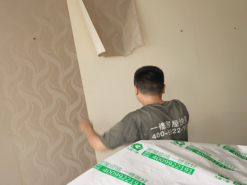 客廳墻面墻紙鏟除：盡量貼近墻面，捏住墻紙的一角，試著將其從墻面上揭下。朝著自己的方向?qū)垊冸x墻面，這樣更容易揭下墻紙。如果不容易撕的話，可以在墻面滾刷一些肥皂水，然后用美工刀、剃刀片或墻紙刮刀，沿水平方向?qū)⑴f墻紙割開，讓溫肥皂水或墻紙剝除劑滲到墻紙的后面，軟化粘合劑，然后就可以從石膏墻上撕除或刮除墻紙了。