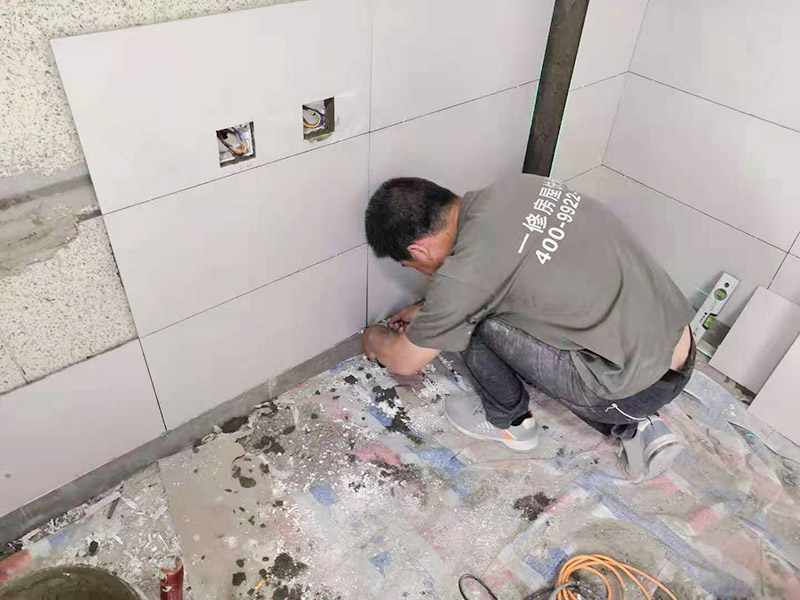 墻磚鋪貼施工：鋪貼時緊靠已鋪好的標準高度面開始施工，并用拉出的對縫平直線來控制瓷磚對縫的平直。鋪貼時水泥漿應(yīng)飽滿的抹干瓷磚背面，并用橡皮錘敲實，以防止空鼓現(xiàn)象。并且一邊鋪貼一邊用水平尺檢查校正。并即刻擦去表面的水泥漿。